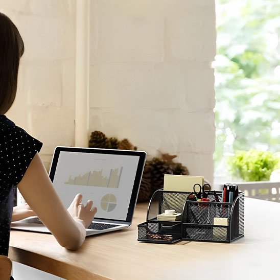 Organisateur de bureau noir en maille a cote d'un laptop