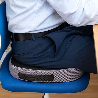 coussin ergonomique support dorsal avec un homme assis dessus